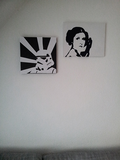 Two black and white Star Wars pictures of a starm trooper and princess Leia hanging on the wall.